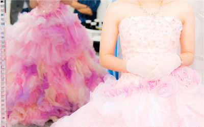 鏡を背にピンクのカラードレスを着て立つ新婦様。
